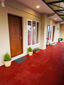 a hallway with a wooden door and potted plants at Rosewood Camellia - Near Ooty Town in Ooty