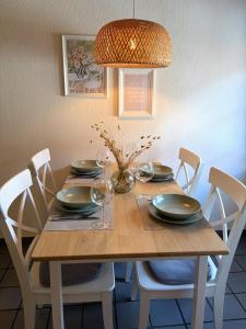 a dining room table with chairs and a chandelier at Dat Lüttje in Fehmarn