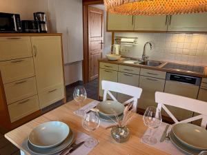 a kitchen with a table with plates and wine glasses at Dat Lüttje in Fehmarn