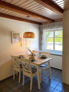 a dining room with a wooden table and chairs at Dat Lüttje in Fehmarn +5 photos