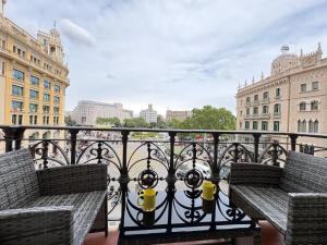 zwei Bänke auf einem Balkon mit Blick auf die Stadt in der Unterkunft Hotel Ginebra in Barcelona