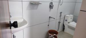 a white bathroom with a sink and a toilet at Kanchan Grace in Vaduvanchal