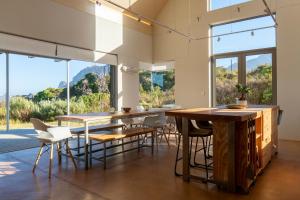 a room with tables and chairs and large windows at The Dunes Pringle Bay in Pringle Bay