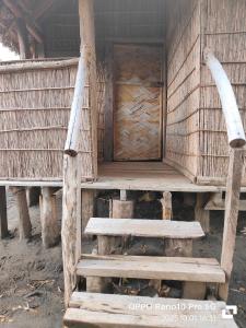 a wooden house with stairs leading to a door at Montanna bungalow in Lénakel +1 photo