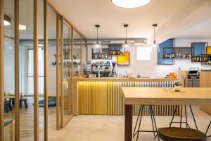 a kitchen with a yellow counter and a table at Alpencolor Hotel Tonale in Passo del Tonale