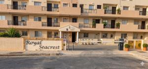 a hotel with a sign in front of a building at Sunshine Royal Seacrest- Prime Location Paphos with Pool in Paphos