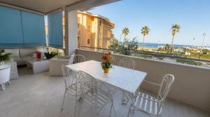 a white table and chairs on a balcony with the ocean at Sea Colors Apartment in Montesilvano