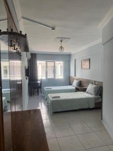 a bedroom with two beds and a living room at Kışla Pansiyon in Antalya