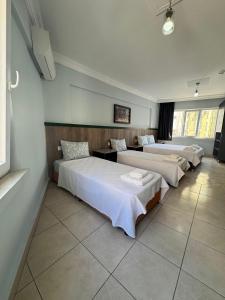 three beds are lined up in a room at Kışla Pansiyon in Antalya
