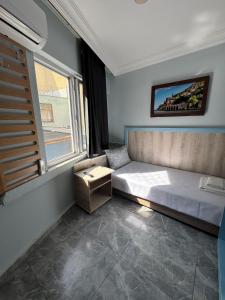 a bedroom with a large bed with a window at Kışla Pansiyon in Antalya +28 photos