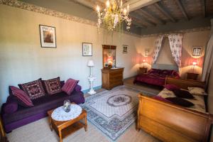 uma sala de estar com um sofá e uma cama em Chambres d'hôtes La Ferme du Grand Launay em Semblançay