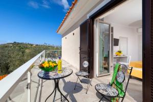a balcony with a table and chairs with a view at Villa Hemera - Mediterranean elegance with private jacuzzi and Capri views in Massa Lubrense