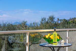 a bowl of fruit on a table with a bottle at Villa Hemera - Mediterranean elegance with private jacuzzi and Capri views in Massa Lubrense