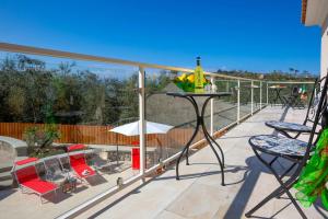 a balcony with chairs and a table with a bottle of wine at Villa Hemera - Mediterranean elegance with private jacuzzi and Capri views in Massa Lubrense