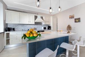 a kitchen with a bowl of fruit on a counter at Villa Hemera - Mediterranean elegance with private jacuzzi and Capri views in Massa Lubrense +41 photos