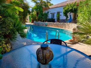 a table with a vase on it next to a swimming pool at Cortijo Paraiso Pool & Tropical Garden Oasis in Cúllar de Baza