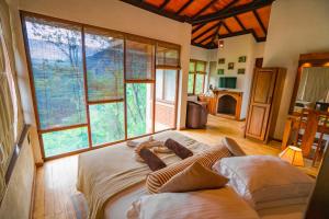 ein Zimmer mit zwei Betten in einem Zimmer mit großen Fenstern in der Unterkunft Tea Cottage Resort - Nawalapitiya in Kandy