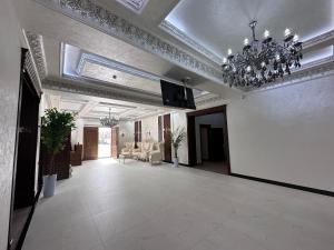 a large room with a chandelier and a living room at Premium Ark Hotel in Bukhara