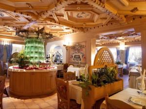 フォルガリーアにあるHotel Villa Wilmaのテーブルと椅子が備わる広い部屋を提供するレストラン