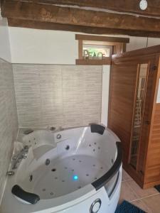 a large white bath tub in a bathroom at Gîte l'étable détente SALLE SPA EN SUPPLEMENT in Vautorte +22 photos