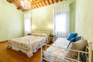 a bedroom with two beds and a chandelier at Ca'trecamini in Ca Dolfin