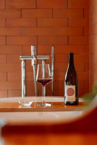 eine Flasche Wein und ein Glas auf einer Badewanne in der Unterkunft Easterly Room 02 in Chanthaburi
