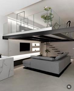 ein Wohnzimmer mit grauem Sofa und einer Treppe in der Unterkunft The loft 87 in San Giovanni in Fiore