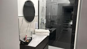 ein Badezimmer mit Waschbecken und Dusche mit Spiegel in der Unterkunft The loft 87 in San Giovanni in Fiore + 11 Fotos