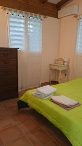 Bungalow Belem de l'Anse des rochers في سانت فرانسوا: غرفة نوم بسرير اخضر وطاولة