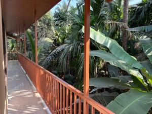 a wooden porch with a bunch of palm trees at Seven Seas Beach Resort in Diveagar