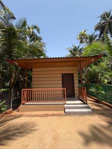 a small cabin with a porch and a porch at Seven Seas Beach Resort in Diveagar