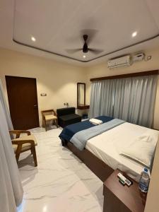 a bedroom with a large bed and a couch at Seven Seas Beach Resort in Diveagar