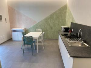 a kitchen with a sink and a table with chairs at B&B Il Viale in Ponte dellʼOlio