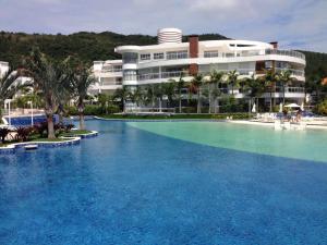 a large swimming pool in front of a building at Flat 3 suites frente mar in Florianópolis