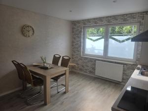 a dining room with a table and chairs and a clock at Ferienhaus Anna in Übach-Palenberg