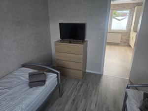 a bedroom with a bed and a flat screen tv at Ferienhaus Anna in Übach-Palenberg