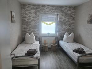two beds in a room with a window at Ferienhaus Anna in Übach-Palenberg