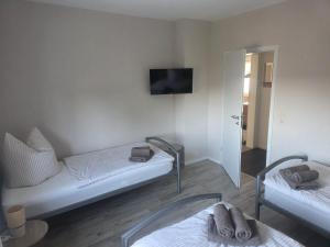 a room with two beds and a tv on the wall at Ferienhaus Anna in Übach-Palenberg +3 photos