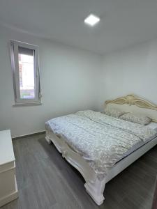 a bed in a white room with a window at Bela Bar in Pečurice