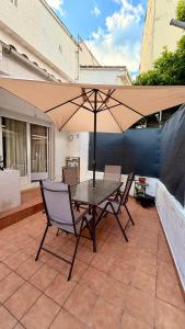 a table and chairs with an umbrella on a patio at El Balcón de Gredos in Candeleda