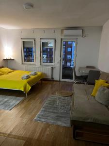 a living room with two beds and a couch at Unik's Studio Apartment in Prizren