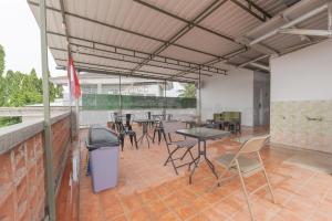 a patio with tables and chairs and a trash can at Adam Guesthouse Mitra RedDoorz in Bogor +16 photos