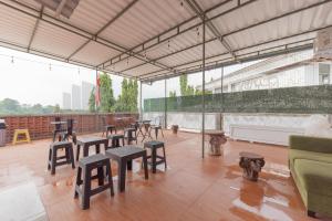 a group of tables and stools in a room at Adam Guesthouse Mitra RedDoorz in Bogor