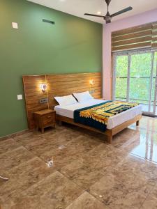 a bedroom with a bed and a green wall at Bella Casa in Vagamon