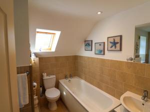 a bathroom with a tub and a toilet and a sink at Rosemarie Annexe in Axminster +18 photos