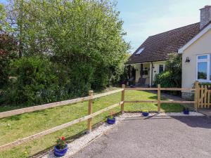 a wooden fence in front of a house at Rosemarie Annexe in Axminster