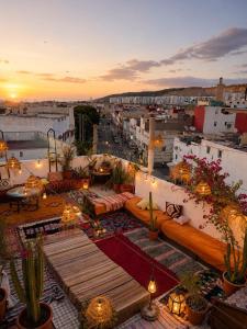 a rooftop patio with couches and cacti on a building at Riad Boya Surf - Lodge in Agadir