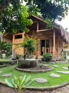 a small wooden house with a grass roof at Beda gaya ecolodge Rangsot 2 in Tanjung