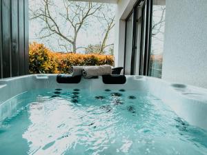 a jacuzzi tub in a room with a window at M26 Prémium apartmanok in Tihany