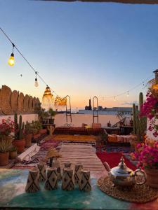 a patio with a view of the water and a sunset at Riad Boya Surf - Lodge in Agadir +26 photos